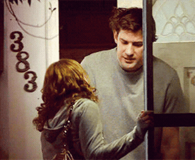 A Man And A Woman Standing In Front Of A Door With The Number 3333 On It GIF