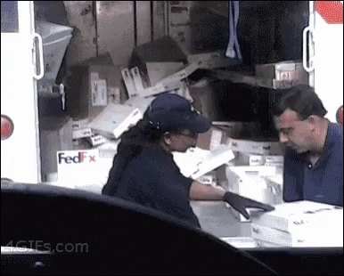 A Man And A Woman Standing In Front Of A Fedex Truck . GIF