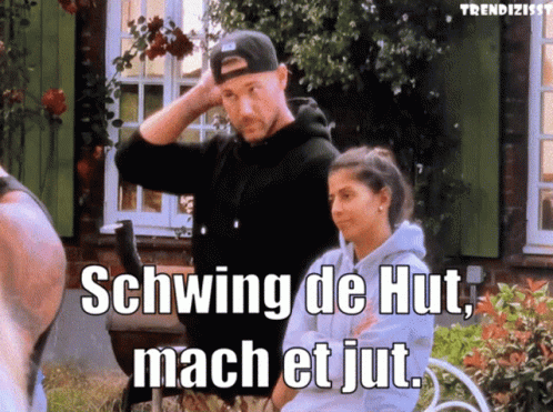 A Man And A Woman Standing In Front Of A House With Schwing De Hut Mach Et Jut Written On The Screen GIF