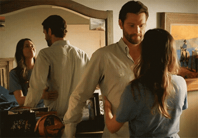 A Man And A Woman Standing In Front Of A Mirror GIF