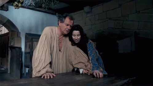 A Man And A Woman Standing Next To Each Other GIF