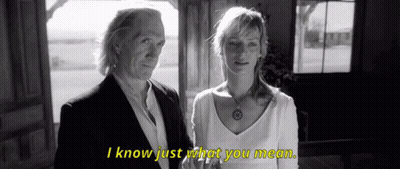 A Man And A Woman Standing Next To Each Other With I Know Just What You Mean Written In Yellow GIF