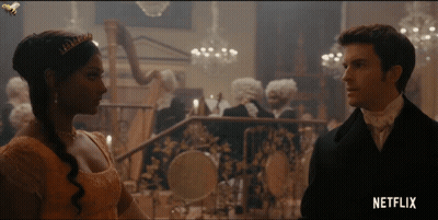 A Man And A Woman Standing Next To Each Other With Netflix Written On The Bottom Right GIF