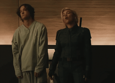 A Man And A Woman Standing Next To Each Other GIF