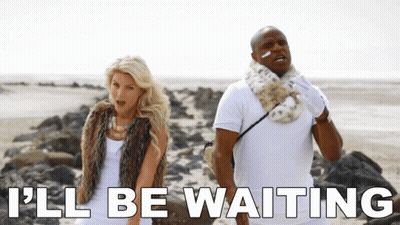 A Man And A Woman Standing On A Beach With The Words " I 'Ll Be Waiting " Below Them GIF