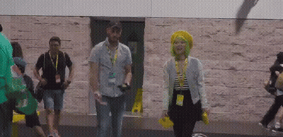 A Man And A Woman Walking In Front Of A Building GIF