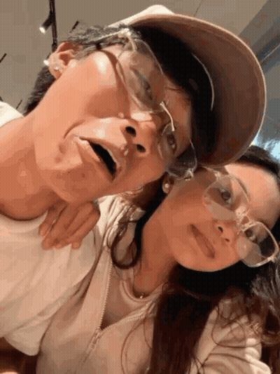 A Man And A Woman Wearing Glasses Are Posing For A Picture Together . GIF