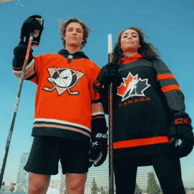 A Man And A Woman Wearing Jerseys That Say Canada GIF