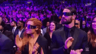 A Man And A Woman Wearing Virtual Reality Glasses Are Sitting In A Crowd . GIF