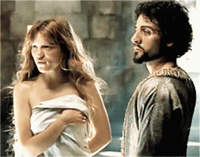 A Man And A Woman Wrapped In A Towel Are Standing Next To Each Other GIF