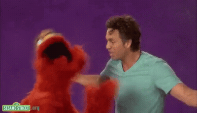 A Man And Elmo From Sesame Street Are Dancing Together . GIF