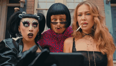 A Man And Two Women Are Standing Next To Each Other GIF
