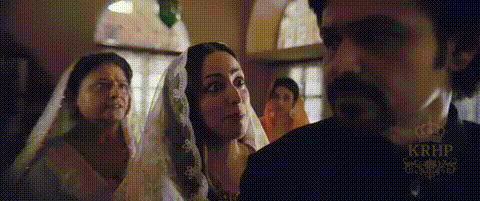 A Man And Two Women Are Standing Next To Each Other In A Room . One Of The Women Is Wearing A Veil . GIF