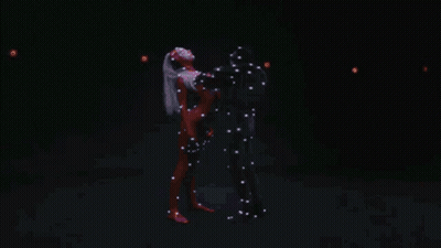 A Man And Woman Are Dancing In A Dark Room GIF