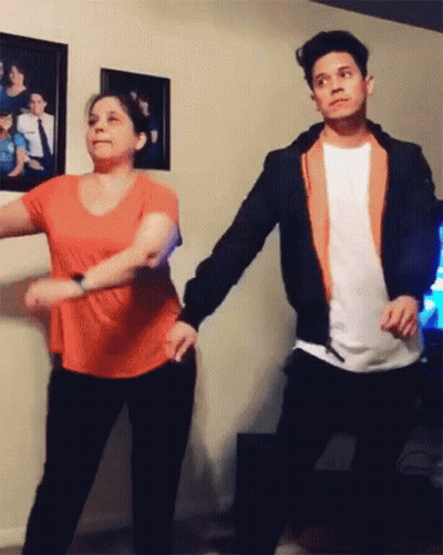 A Man And Woman Are Dancing In A Living Room GIF