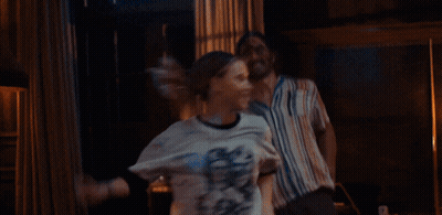 A Man And Woman Are Dancing In A Room With Lamps GIF