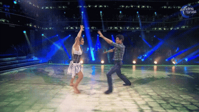 A Man And Woman Are Dancing In Front Of A Dancing Break Sign GIF