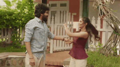 A Man And Woman Are Dancing In Front Of A White Picket Fence GIF