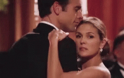 A Man And Woman Are Dancing Together In A Ballroom . GIF