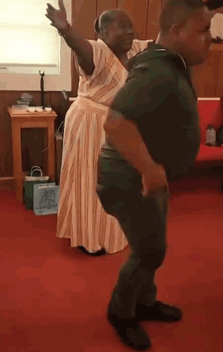 A Man And Woman Are Dancing Together In A Room . GIF