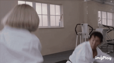 A Man And Woman Are Fighting In A Gym . GIF