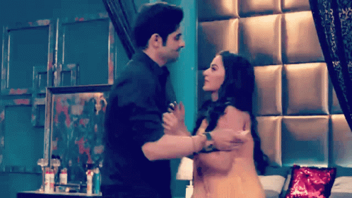 A Man And Woman Are Hugging In A Bedroom GIF