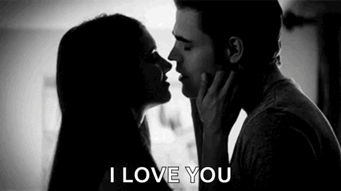 A Man And Woman Are Kissing In A Black And White Photo . GIF