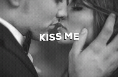 A Man And Woman Are Kissing In A Black And White Photo . GIF