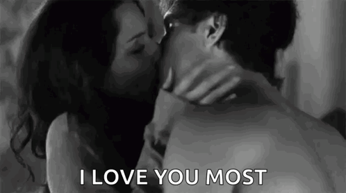 A Man And Woman Are Kissing In A Black And White Photo . GIF