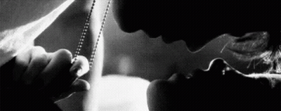 A Man And Woman Are Kissing In A Black And White Photo . GIF
