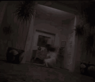 A Man And Woman Are Kissing In A Dark Room . GIF