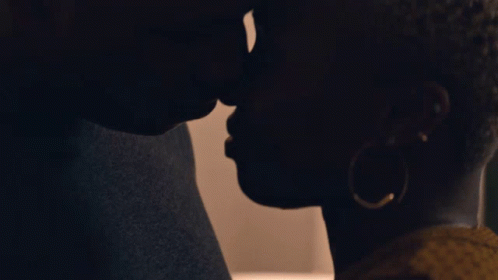 A Man And Woman Are Kissing In The Dark GIF