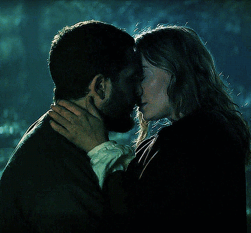 A Man And Woman Are Kissing In The Dark GIF
