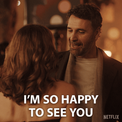 A Man And Woman Are Looking At Each Other And The Man Is Saying I 'M So Happy To See You GIF