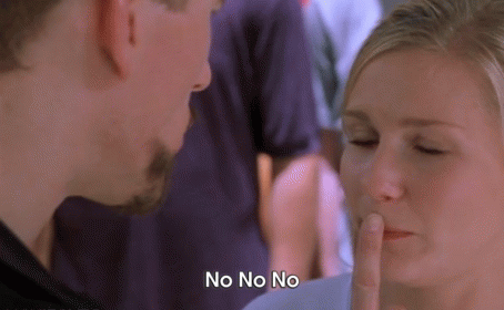 A Man And Woman Are Looking At Each Other And The Woman Is Covering Her Mouth With Her Finger And The Man Is Saying No N GIF