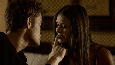 A Man And Woman Are Looking At Each Other And The Woman Is Holding Her Finger To Her Lips GIF