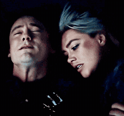 A Man And Woman Are Looking At Each Other In The Dark GIF