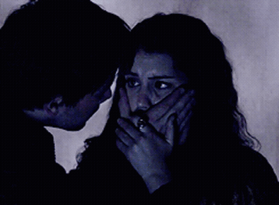 A Man And Woman Are Looking At Each Other In The Dark GIF