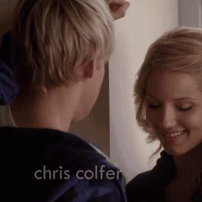A Man And Woman Are Looking At Each Other With The Name Chris Colfer On The Bottom GIF