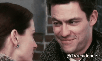 A Man And Woman Are Looking Into Each Other 'S Eyes And Smiling . GIF