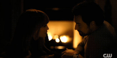 A Man And Woman Are Looking Into Each Other 'S Eyes With A Cw Logo In The Background GIF