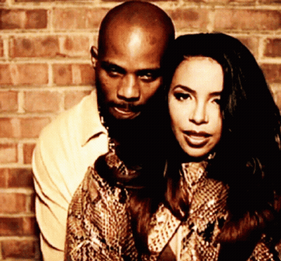 A Man And Woman Are Posing For A Photo In Front Of A Brick Wall GIF