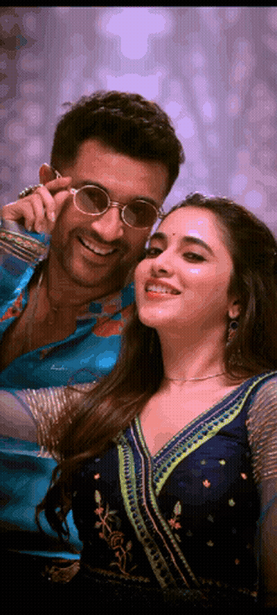 A Man And Woman Are Posing For A Picture And The Woman Is Wearing Sunglasses GIF