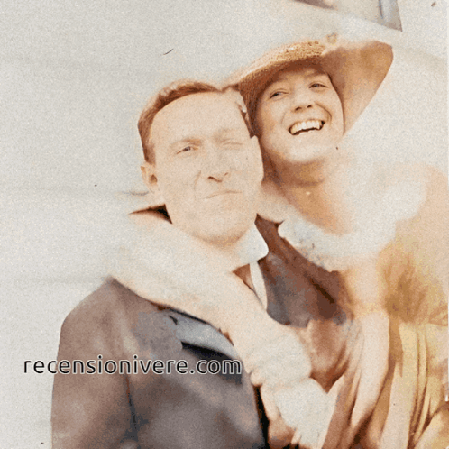 A Man And Woman Are Posing For A Picture With The Website ' Recensionivere.com ' On The Bottom Right GIF