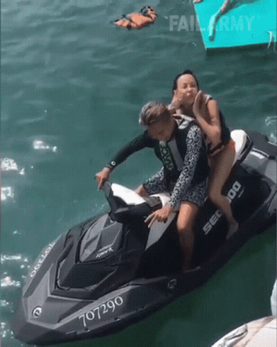 A Man And Woman Are Riding A Jet Ski With The Number 707290 GIF