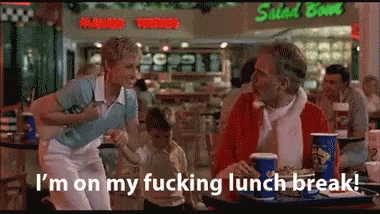 A Man And Woman Are Sitting At A Table In Front Of A Salad Bowl GIF