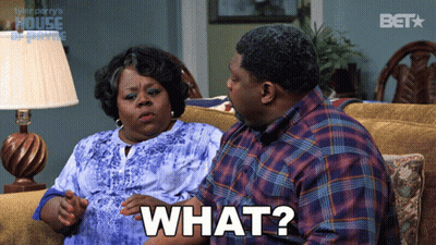 A Man And Woman Are Sitting On A Couch And The Man Is Saying " What " GIF