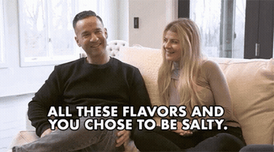 A Man And Woman Are Sitting On A Couch With The Words " All These Flavors And You Chose To Be Salty " GIF