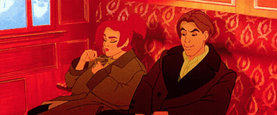 A Man And Woman Are Sitting On A Red Couch GIF