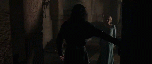 A Man And Woman Are Standing In A Dark Room GIF